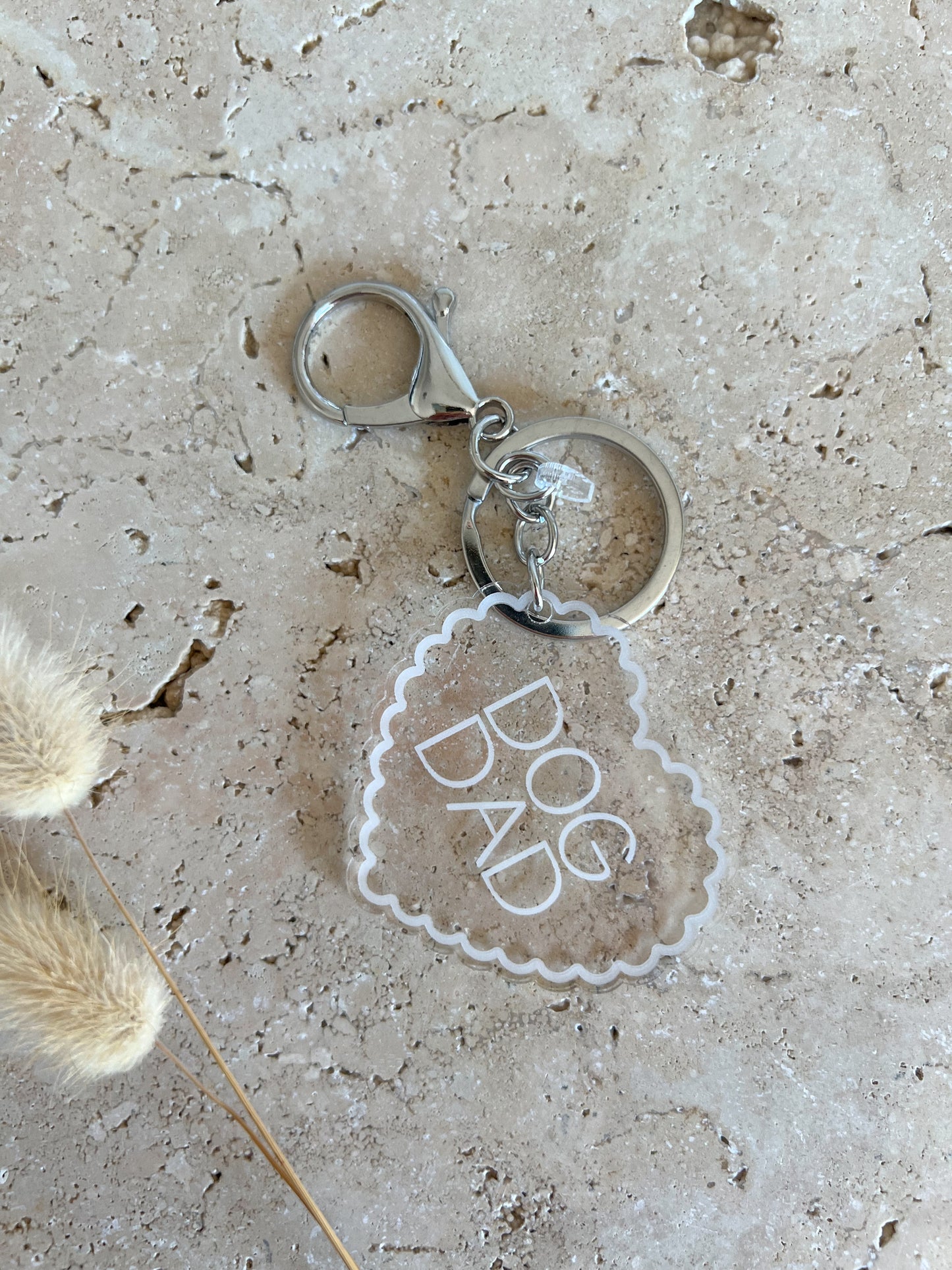 Keychain with 'DOG DAD' tag on a textured surface