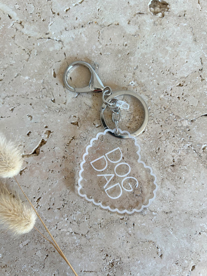 Keychain with 'DOG DAD' tag on a textured surface