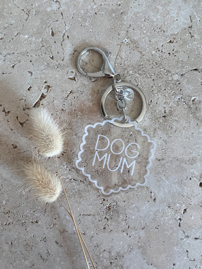 Keychain with 'DOG MUM' text on a textured surface with a dried plant.