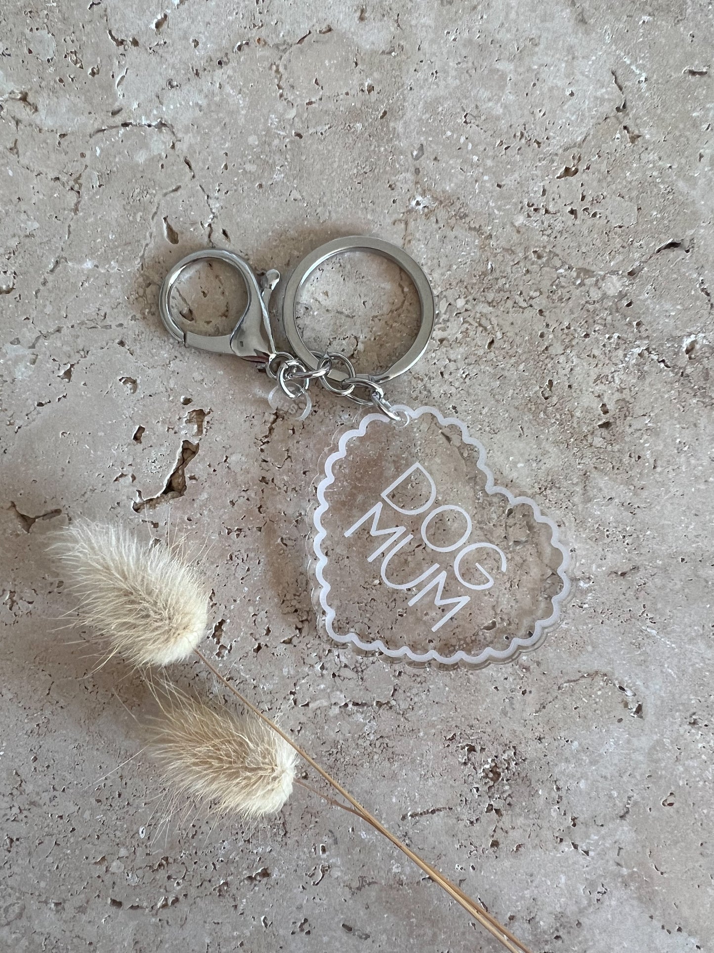 Keychain with 'DOG MUM' text on a textured surface