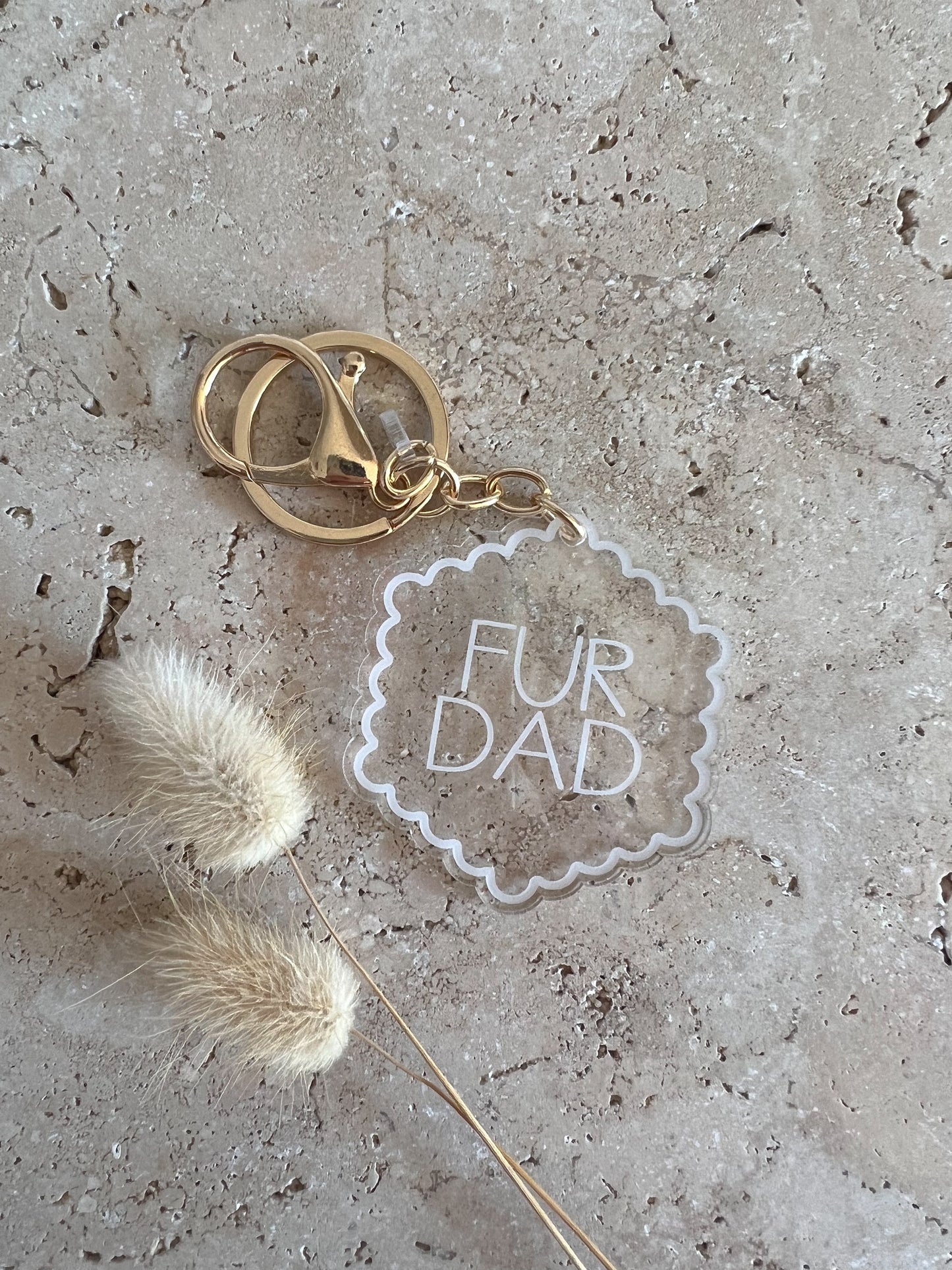Keychain with 'Fur Dad' tag on a textured surface