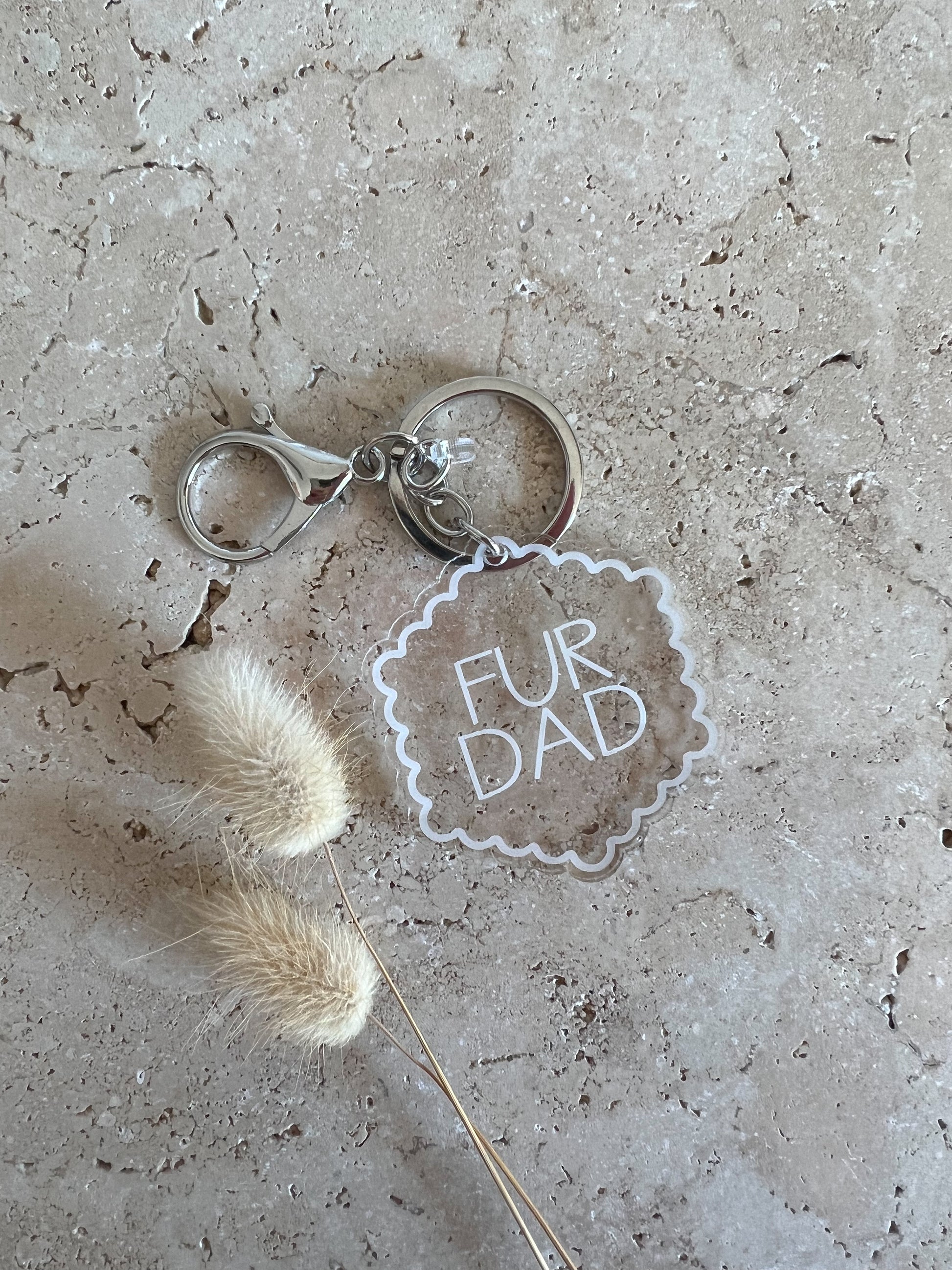 Keychain with 'Fur Dad' tag on a textured surface