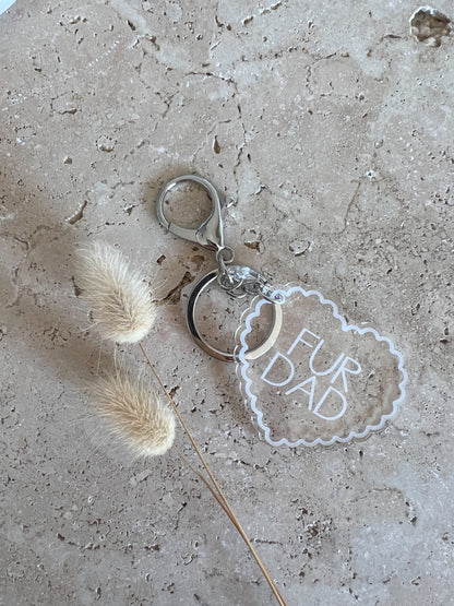 Keychain with 'Fur Dad' tag on a textured surface