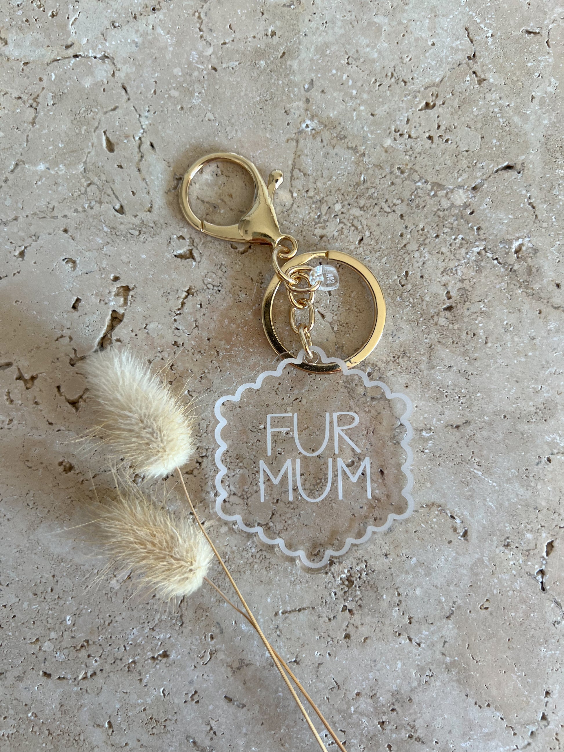 Keychain with 'FUR MUM' tag on textured surface
