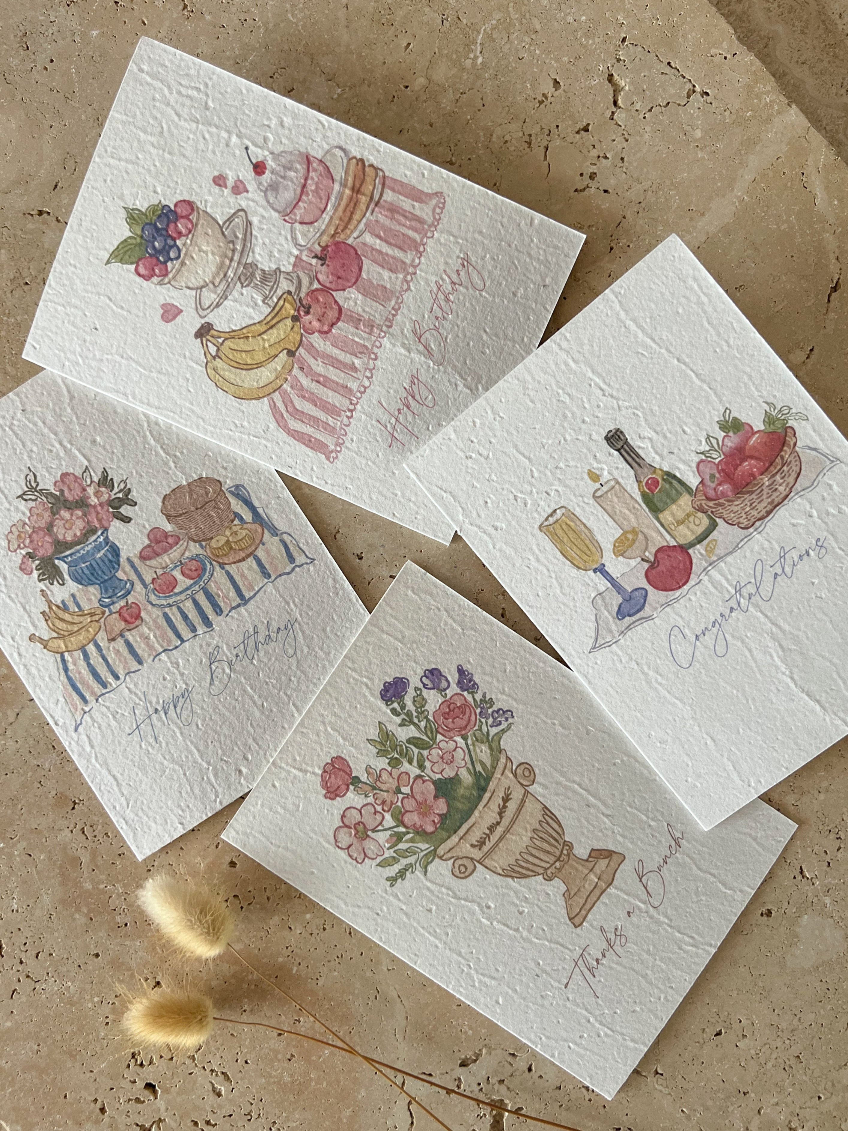 Set of four illustrated plantable greeting cards on a textured surface