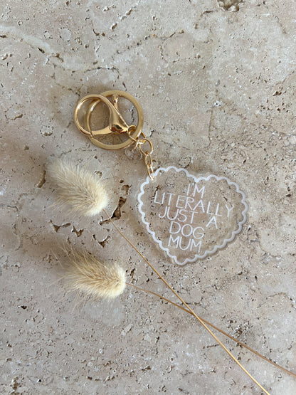 Keychain with heart-shaped tag reading 'I'm literally just a dog mum' on a textured surface.