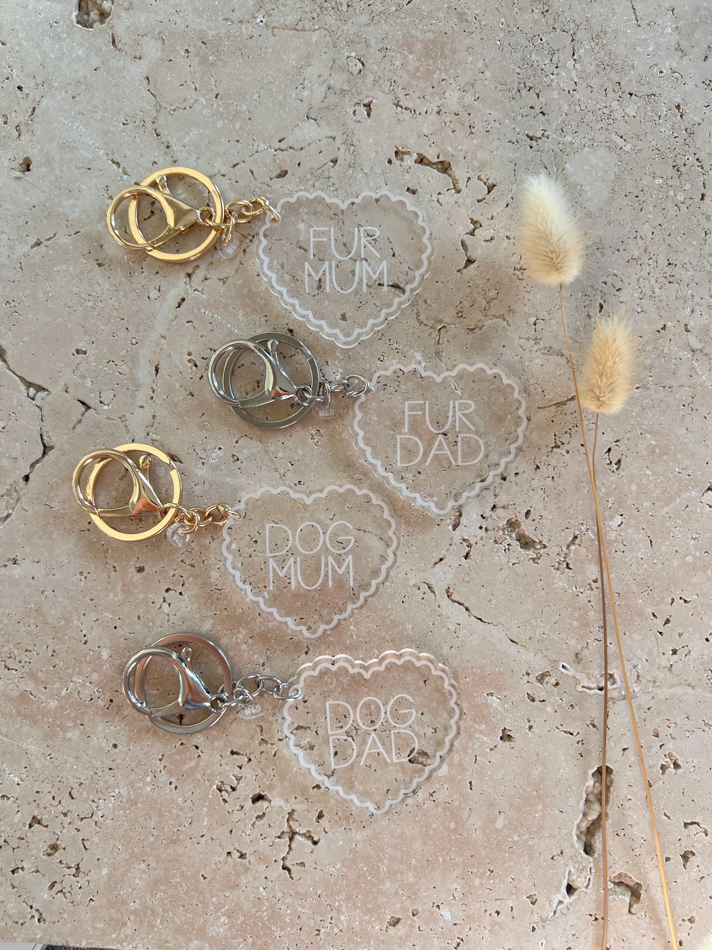 Heart-shaped keychains with 'Fur Mum', 'Fur Dad', 'Dog Mum', and 'Dog Dad' text on a textured surface.