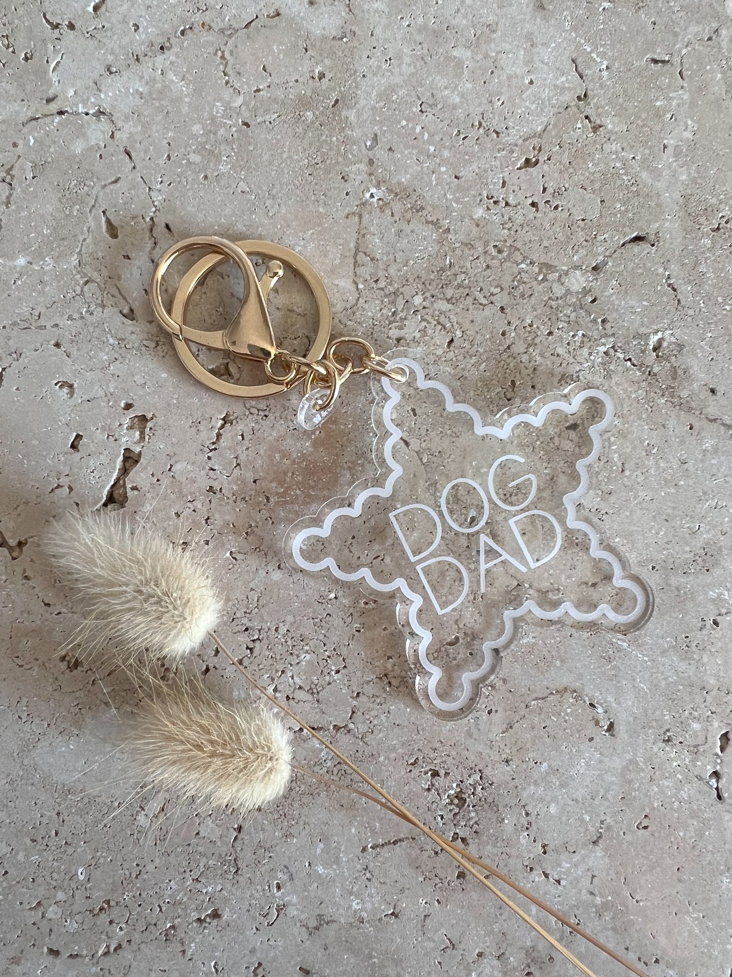 Keychain with 'DOG DAD' star-shaped tag on a textured surface