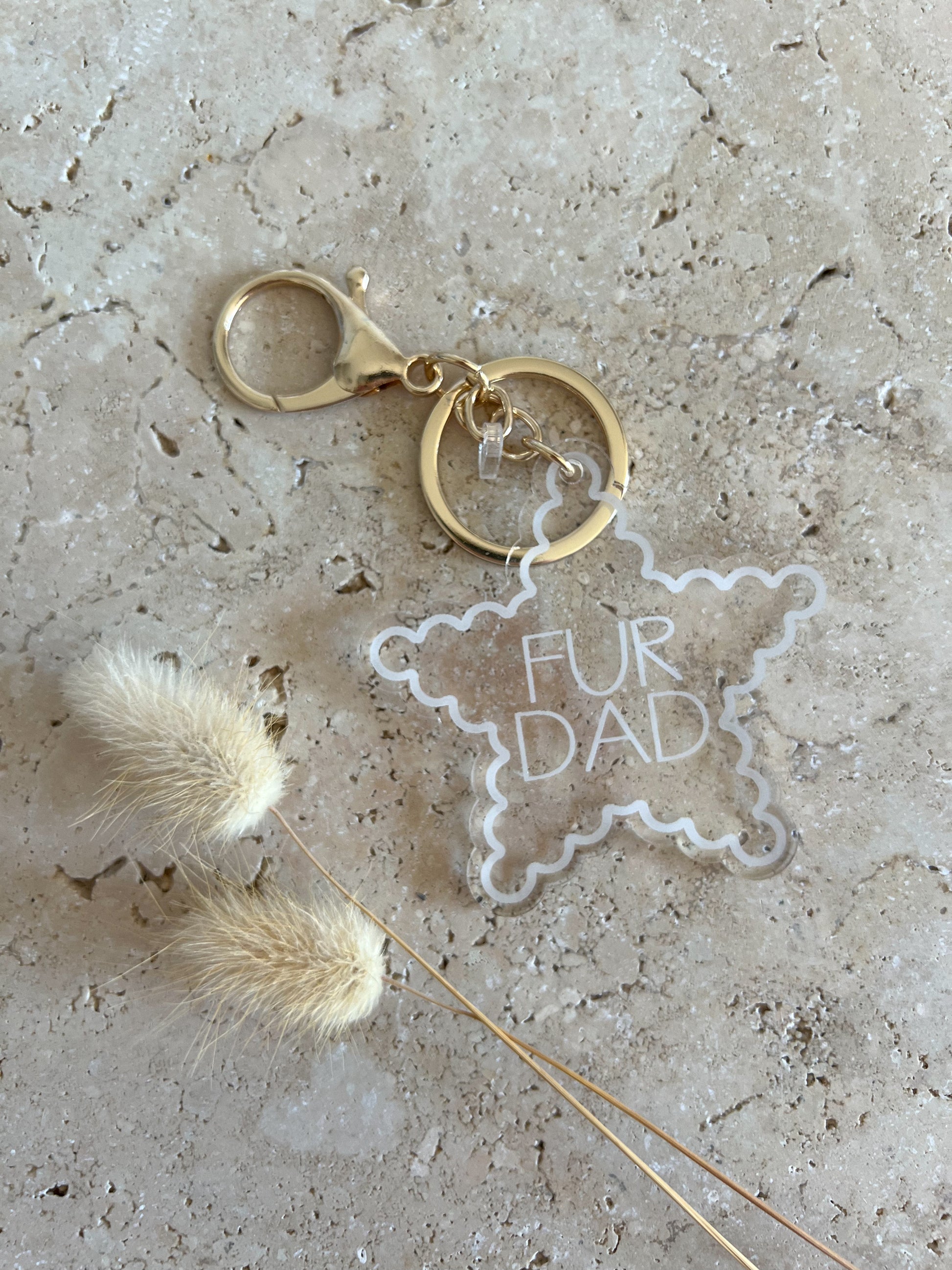 Keychain with 'Fur Dad' tag on a textured surface