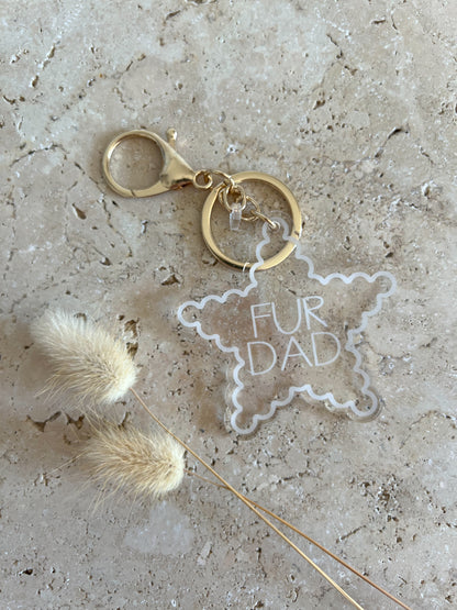 Keychain with 'Fur Dad' tag on a textured surface