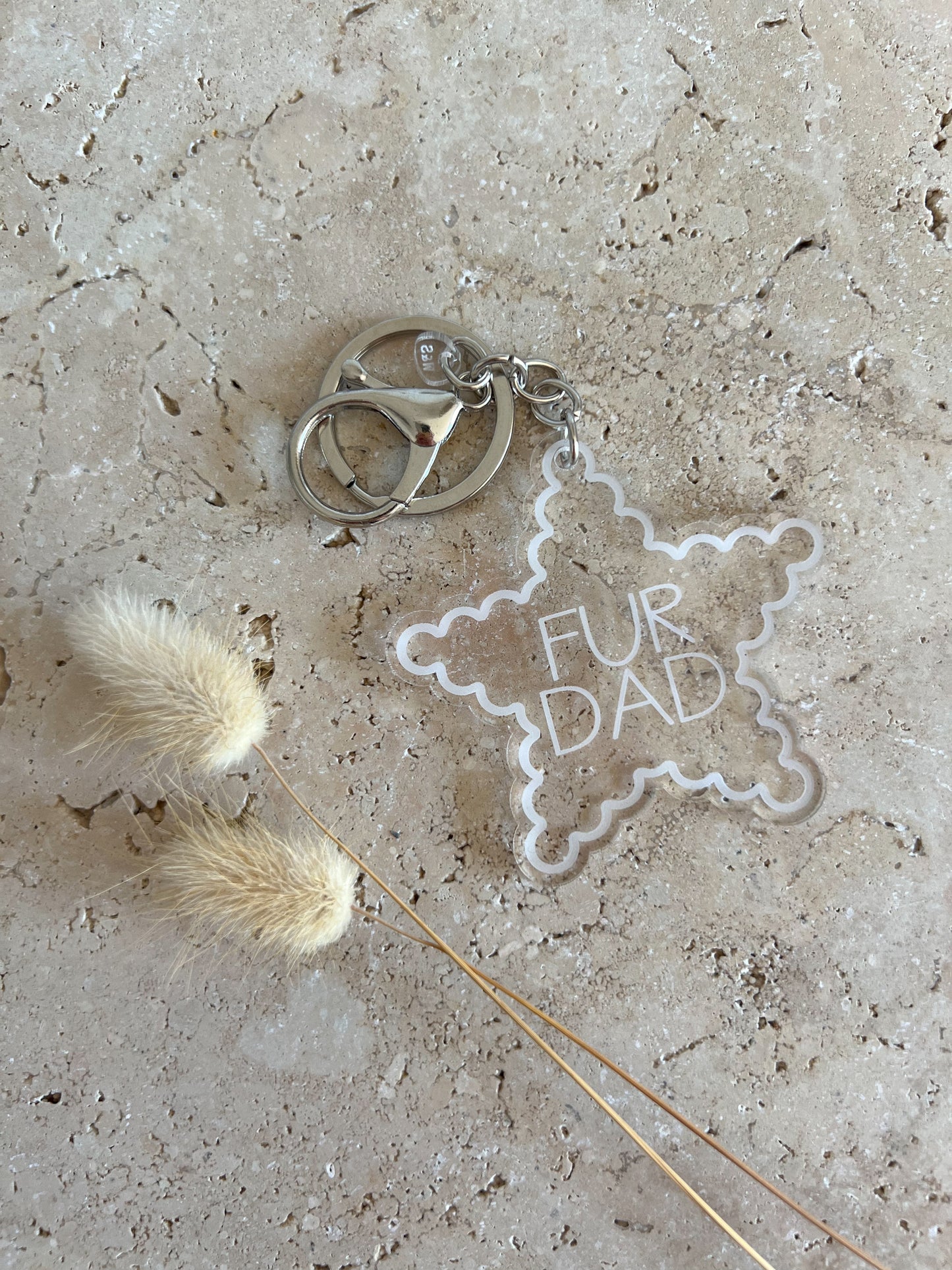 Star-shaped keychain with 'Fur Dad' text on a textured surface